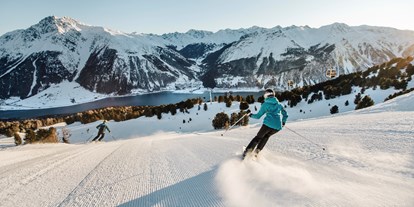 Skiregion - Après Ski im Skigebiet: Schirmbar - Trentino-Südtirol - Höllentalabfahrt mit Blick auf den Reschensee - Skigebiet Schöneben-Haideralm