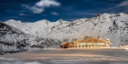 Skiregion - Skiverleih bei Talstation - Tiroler Oberland - Hohe Mut Alm.
Hochgenuss am schönsten Bergrücken Tirols

Der Aussichtsberg Hohe Mut am südlichen Rand des Skigebiets serviert einen Rundumblick auf 21 Dreitausender und Gletscher. Doch damit nicht genug: Das 2.670 m hoch gelegene Bergrestaurant Hohe Mut Alm garniert die Aussicht mit kulinarischen Kreationen auf höchstem Niveau. Auf der großen Sonnenterrasse verschmelzen alle Sinneseindrücke zu einem einzigen Wort: Wow! Highlight jeden Mittwoch ab 18.30 Uhr ist der beschwingte Hüttenabend.

Glanzstück der Berggastronomie.
Neben der Bergstation der Hohe Mut Bahn II heißt die gemütliche Hohe Mut Alm hungrige Wintersportler willkommen. Viel Holz im traditionellen alpinen Stil erfüllt die Stuben mit warmer Gastlichkeit. Große Panorama-Fenster öffnen den Raum nach draußen, wo die Terrasse als chillige Lounge und sonniger Logenplatz zum Naturschauspiel dient. Passend zu diesem ganz und gar nicht alltäglichen Ambiente schmeckt auch die Kochkunst nach Mehr: Qualität, Hingabe und Raffinesse.

Jeden Mittwoch ab Mitte Dezember klingt der Skitag in Obergurgl-Hochgurgl am besten beim Hüttenabend in der Hohe Mut Alm aus. Auffahrt (kostenlos) ist um 18.30 Uhr – mit der topmodernen 8er-Kabinenbahn gelangt man komfortabel in 9 Minuten vom Ortszentrum Obergurgl zur Bergstation. Zum Empfang wärmt ein Punsch aus dem Kupferkessel, bevor das aufmerksame Service-Team ein Gourmetfondue mit Filets, Garnelen und vielen anderen Delikatessen auftischt. Livemusik krönt die Hüttengaudi in den Stuben, bevor es zurück ins Tal geht (Abfahrt ab 22.30 Uhr).

„Ja, ich will“: Immer mehr Paare sprechen die magischen drei Worte mitten im Obergurgler Winter aus. Die 2.670 m hoch gelegene Hohe Mut Alm hat sich als beliebte Hochzeitslocation etabliert und erfüllt alle Wünsche an den schönsten Tag des Lebens. So schwebt das Brautpaar in einer festlich geschmückten Hochzeitsgondel hinauf zur standesamtlichen Trauung am Berg, wo bis zu 230 Gäste auf der Sonnenterrasse und in exklusiven Stuben Platz finden. Auch um das Festmenü, Dekoration, Musik und Fotografen kümmern sich die Gastgeber gerne. Nur noch Ja sagen müssen Sie selbst. - Skigebiet Gurgl