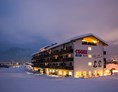 Unterkunft: Das Hotel in einer klaren Winternacht - COOEE alpin Hotel Kitzbüheler Alpen